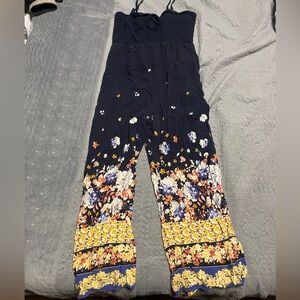 Jumpsuit w/ floral pattern. Slit flare cuffs. Smocked top.